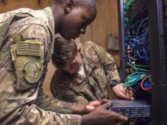 Two U.S. Air Force airmen install network-switch panels at Bagram Airfield, Afghanistan. The Defense Information Systems Agency (DISA) is striving to improve its acquisition processes to procure and deploy innovative information technologies to its customers more quickly.