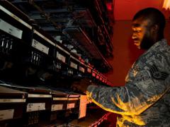 A U.S. Air Force cyber transport systems technician works on an electronic equipment rack at Joint Base Charleston, South Carolina. In addition to traditional cyberthreats, the Air Force is seeing increased cyber activity aimed at bringing down its critical infrastructure at bases in the United States.