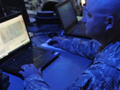 An Army electromagnetic spectrum manager uses a joint spectrum-management planning tool to track mission progress in the field from inside the headquarters tactical operations center as part of Network Integration Evaluation (NIE) in 2014.