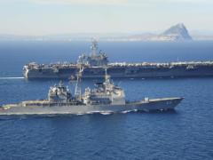 The Ticonderoga-class guided missile cruiser USS Vicksburg, foreground, escorts the Nimitz-class aircraft carrier USS Theodore Roosevelt as they pass the Rock of Gibraltar in the Strait of Gibraltar last March. The Theodore Roosevelt deployed from Norfolk, Virginia, to then make a homeport shift to San Diego at the end of its deployment.