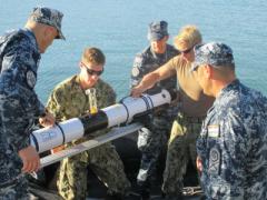 Croatian divers and U.S. sailors with Explosive Ordnance Disposal Mobile Unit (EODMU) 8 load an Iver 3 autonomous underwater vehicle (AUV) into the MK-5 Zodiac for testing.
