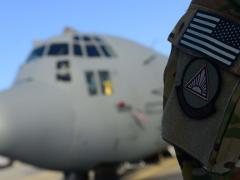 An airman from the 41st Expeditionary Electronic Combat Squadron stands next to an EC-130H Compass Call aircraft in September 2014 at Bagram Air Base, Afghanistan. The squadron provides counter-communications electronic attack capabilities.