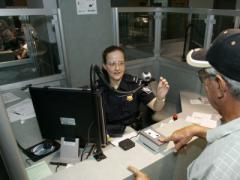 A Customs and Border Protection officer takes biometrics from an arriving foreign visitor. Integrating biometrics into the pre-arrival vetting process is one of the National Vetting Center’s key tasks. Customs and Border Protection