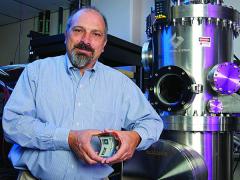 Eric Forsythe, Ph.D., team leader and flexible electronics display deputy project manager with the Army Research Laboratory, poses with some of the equipment used to produce the flexible displays at the Army's Flexible Display Center at Arizona State University.