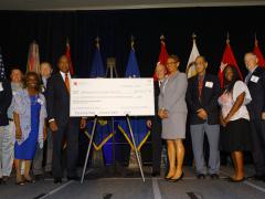 The National Math and Science Initiative presents a check for $455,217 to the schools of Richmond County, Georgia, during the AFCEA TechNet Augusta conference. Photo by Michael Carpenter