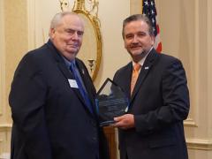 In 2018, the Montgomery Chapter recognizes Chief Master Sgt. Tom Gwaltney, USAF (Ret.) (l), for his contributions to the chapter by naming its Young AFCEAN Award in his honor. Then-Chapter President Brian Knott is also pictured. Chief Gwaltney passed away on March 15, 2020. Credit: Montgomery Chapter