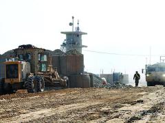 Heavy machinery from the 864th Engineer Battalion, U.S. Central Command Materiel Recovery Element, grade and pack the Afghan dirt as the engineer soldiers reconfigure an old retro sort yard into a material overflow yard.