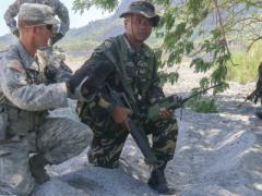 A U.S. soldier with Company A, 2nd Battalion, 3rd Infantry Regiment, explains training scenario options to a Filipino counterpart conducting a dismounted assault rehearsal as part of the Army’s Pacific Pathways training exercise this year.