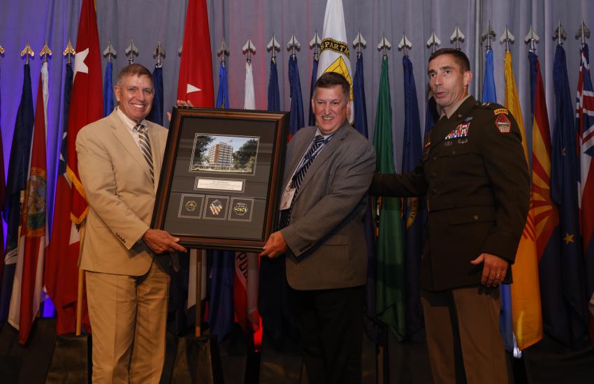 Col. Mike Warlick, USMC (Ret.) receives praise and framed gift from the Cyber Center of Excellence at AFCEA's TechNet Augusta event. After 11 years at AFCEA, Warlick has announced his retirement effective September 30. Credit: Michael Carpenter
