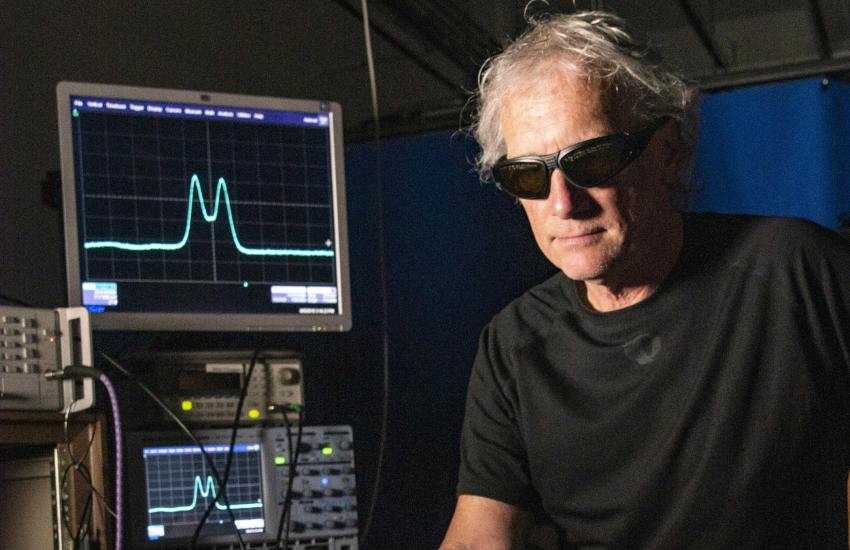 NIST researcher Chris Holloway adjusts a mirror to align a laser beam used in an atom-based receiver for digitally modulated communication signals. Credit: Burrus/NIST