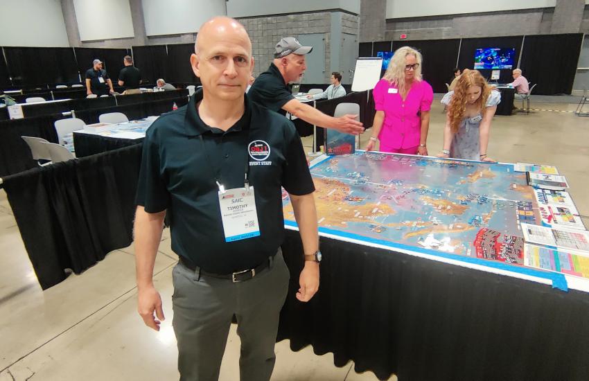 Tim Barrick, director of wargaming at the Krulak Center for Innovation and Future Warfare, Marine Corps University, stands next to a South China Sea map. This was the first time the Modern Marine Day show in Washington, D.C., featured games from think tanks, companies and the U.S. and Canada’s armed services. Photo: Diego Laje.