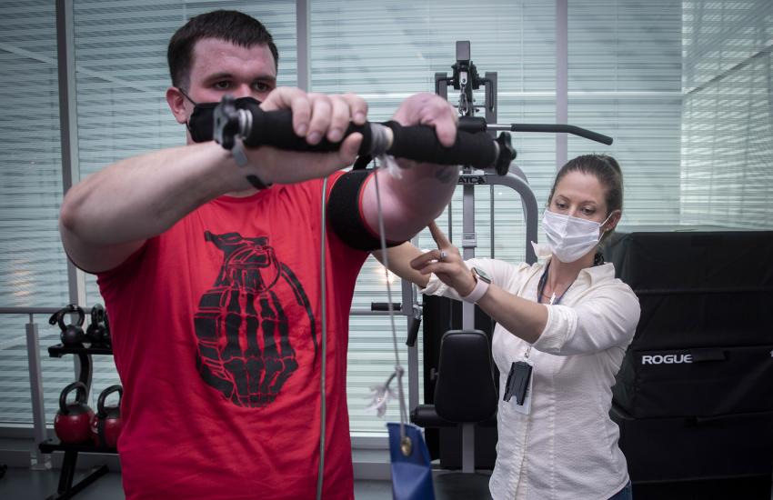 Aimee Toreno, doctor of occupational therapy and certified hand therapist, helps patient John Maloney with rehabilitative exercise at Brooke Army Medical Center’s Center for the Intrepid, Fort Sam Houston, Texas.