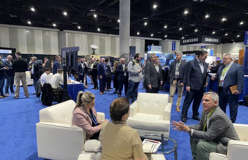 Capt. Katy Boehme (looking away from the camera) speaks with businessmen at an engagement event in during the WEST 2023 conference. Credit: U.S. Navy PEO C4I.