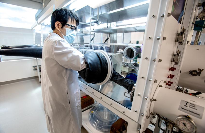 Stanford postdoctoral researcher Stephen Dongmin Kang works at a modular glovebox workstation to observe the behavior of particles made of nickel, manganese, and cobalt, also known as NMC. NMC is one of the most widely used materials in electric vehicles. Credit: Flickr image by U.S. Department of Energy