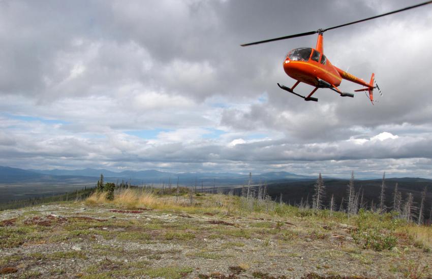 A helicopter in the eastern Yukon-Tanaan region of Alaska prepares to land and pick up geologists mapping in the area near Tok, Alaska. USGS photo by Jamey V. Jones III