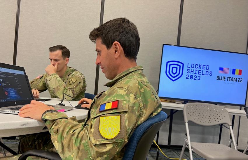 A Romanian armed forces and a U.S. Army officer engage in scenario play during Exercise Locked Shields. Photo credit: Maj. Holli Nelson, U.S. Air National Guard.