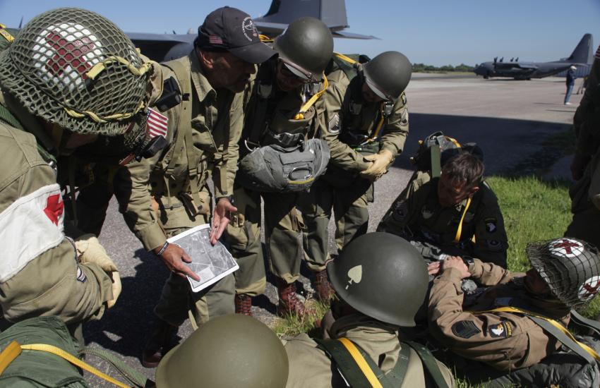 A team of reenactors dressed as American paratroopers prepare their jump at the same landing zone airborne troops droped on in June 1944. Photo credit: Diego Laje, SIGNAL Media.