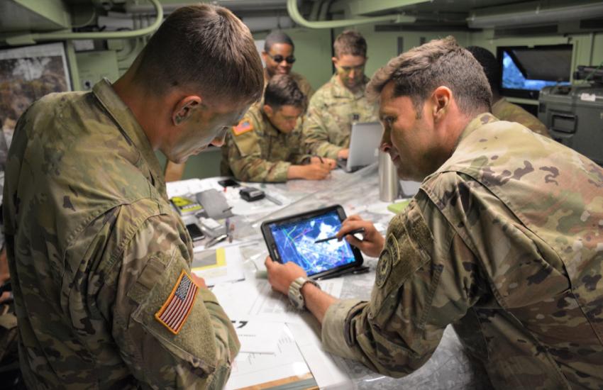 Maj. Matthew Bailey, executive officer, 3rd Squadron, 2d Cavalry Regiment and 1st Lt. Trevor Rubel, battle captain for the tactical command post, 3/2CR, review an operational overlay on a Nett Warrior device in preparation for an airfield seizure during Saber Strike 18 in Kazlu Ruda, Lithuania, June 13, 2018. The end-user device has a multitude of features and programs that connect leadership teams in real time and allows for mission command to succeed.