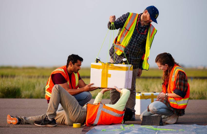 From left to right, Sandia National Laboratories electrical engineer Prabodh Jhaveri, intern Will Barrett, technologist Michael Fleigle and intern Summer Czarnowski prepare a payload for a weather balloon launch. Credit: Craig Fritz