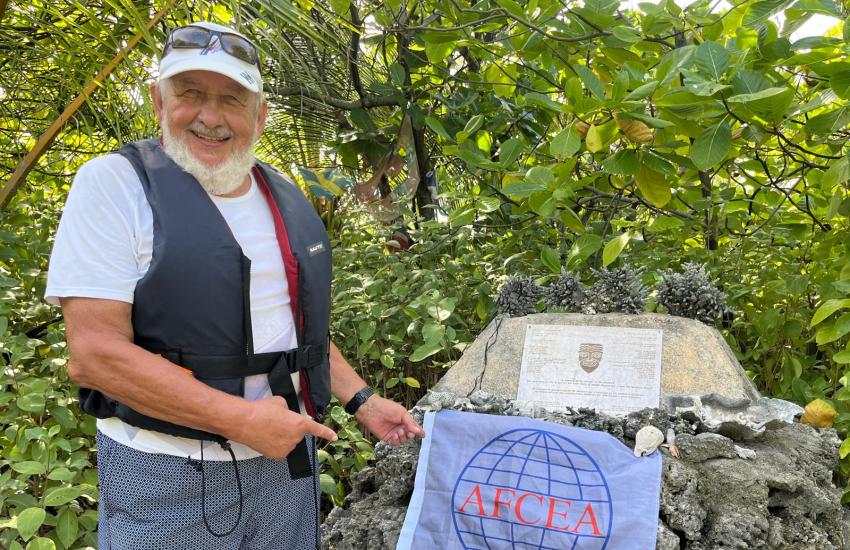 Jüri Grigorjev poses with the AFCEA flag at the Kon Tiki landing monument in Raroia, an atoll in French Polynesia.
