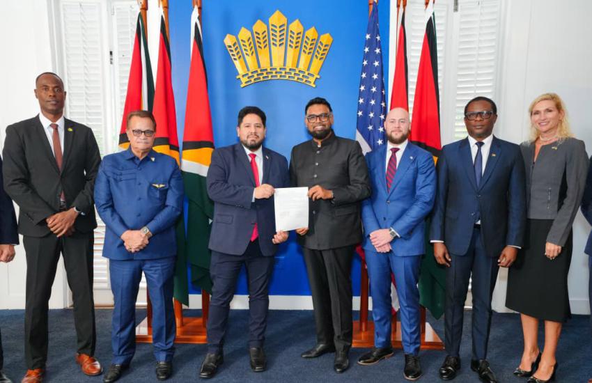 Relations between the United States and Guyana have recently increased. Pictured holding the statement of intent are Joseph Humire, acting assistant secretary for Western Hemisphere Affairs (l), and Irfaan Ali, president of Guyana (r). Patrick Weaver, senior advisor to the U.S. secretary of war, stands to the right of Ali. Credit: Photo from the U.S. Embassy in Guyana site