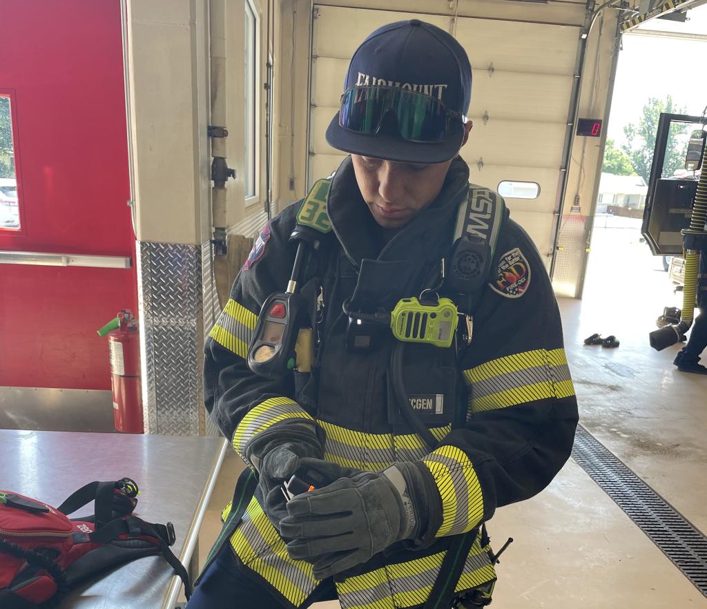 A Fairmount firefighter uses a wearable chemical sensor badge while wearing protective gear to see how well it operates in the field. Credit: TDA Research