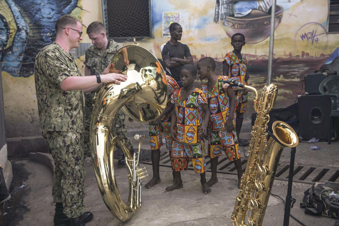 A Navy musician shows his tuba to children during a U.S. Naval Forces Europe and Africa Band concert in Ghana, as part of the diplomacy and cooperation Western armed forces are involved in throughout the continent. Photo By: Navy Petty Officer 2nd Class Trey Fowler