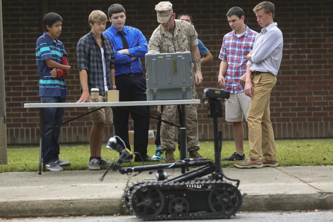 A Marine demonstrates an ordnance disposal robot to high school students. Photo By: Cpl. Michael Dye, U.S. Marine Corps.