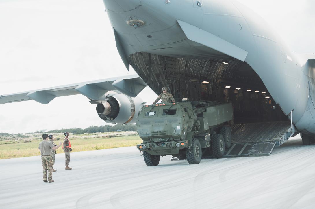 A Hight Mobility Artillery Rocket System vehicle and directs the driver off the tarmac on Andersen Air Force Base, Guam. Photo By: Maj. Jonathon Daniell, U.S. Army.