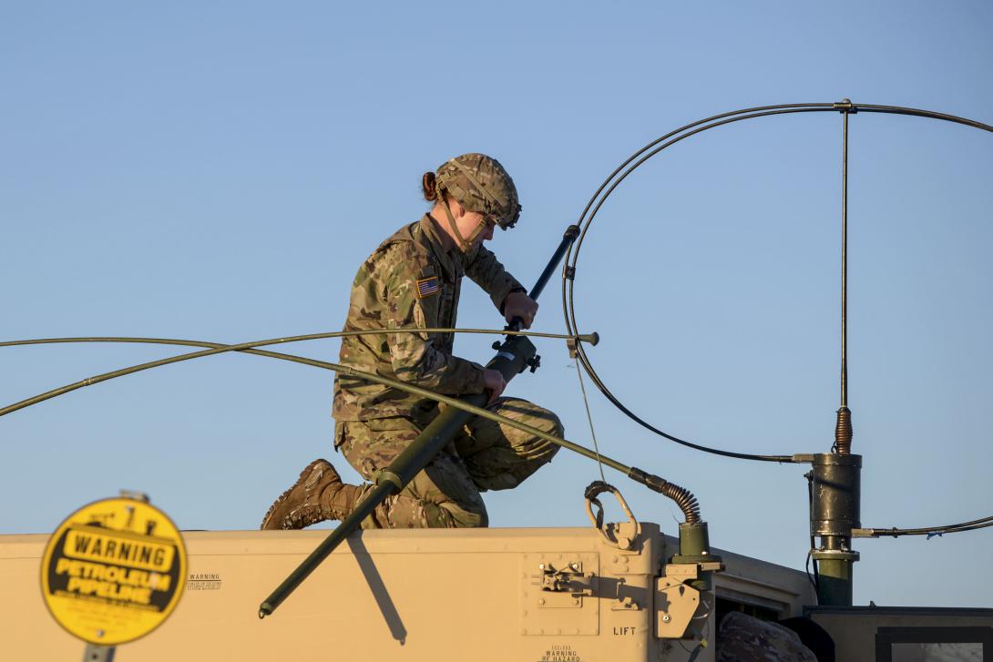 A soldier attaches long-range radio equipment to a Humvee at Fort Greely, Alaska, October 2020. Photo by Air Force Senior Airman Beaux Hebert