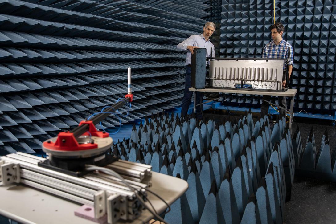 Ryan Westafer (l) and Alex Saad-Falcon, co-lead investigators for the Tensors for Reprogrammable Intelligent Array Demonstrations (TRIAD) program at the Georgia Tech Research Institute, offer a final demonstration setup of the transmitting antenna in the foreground on a metal arm attached to a turntable and the elemental digital array in the background. Credit: Sean McNeil, GTRI