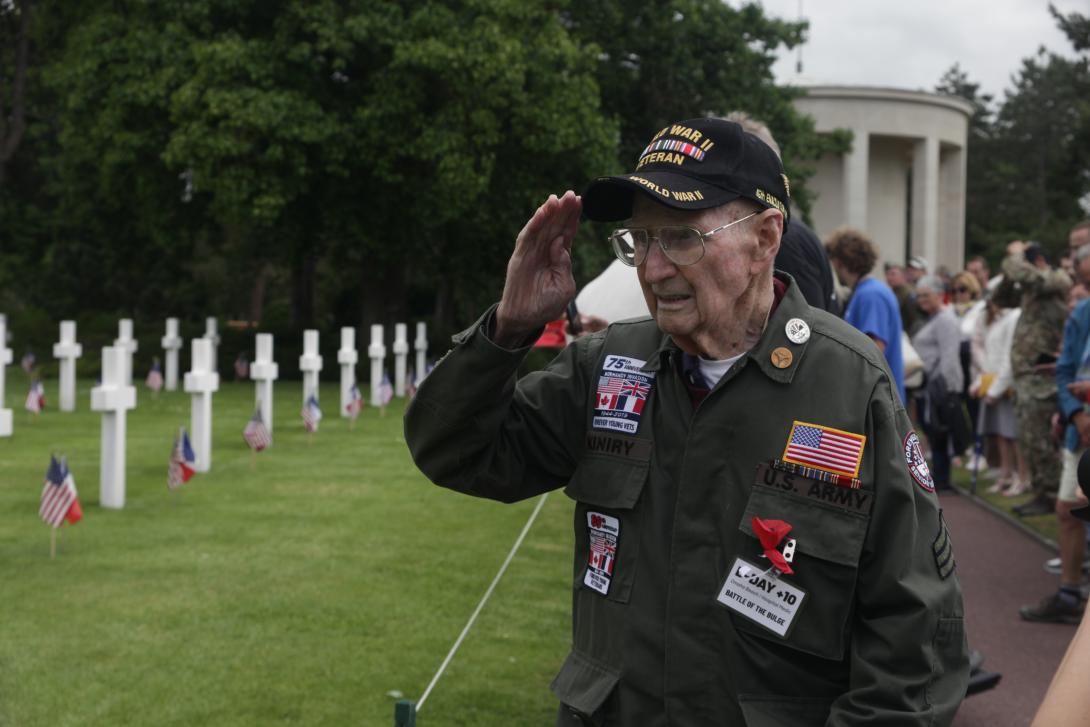 Tim Kiniry, 102, D-Day veteran who served at Omaha Beach as a medic, salutes his comrades at the Normandy American Cemetery. Photo credit: Diego Laje, SIGNAL Media.