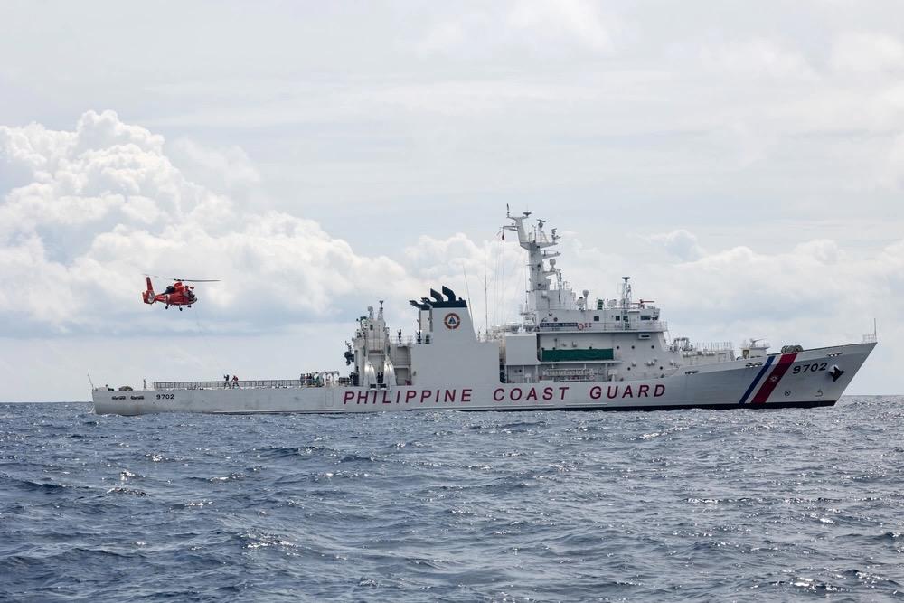 U.S. Coast Guardsmen, assigned to the U.S. Coast Guard Cutter Waesche (WMSL-751), pilot a U.S. Coast Guard MH-65E helicopter over the flight deck of the Philippine Coast Guard Vessel Melchora Aquino (MRRV-9702) during a bilateral U.S.-Philippine search and rescue exercise in the South China Sea on July 16, 2024. To assist the “ever-expanding” missions in the Indo-Pacific region, NGA is testing commercial solutions to help track illicit maritime activity. Credit: USMC photo by Cpl. Elijah Murphy