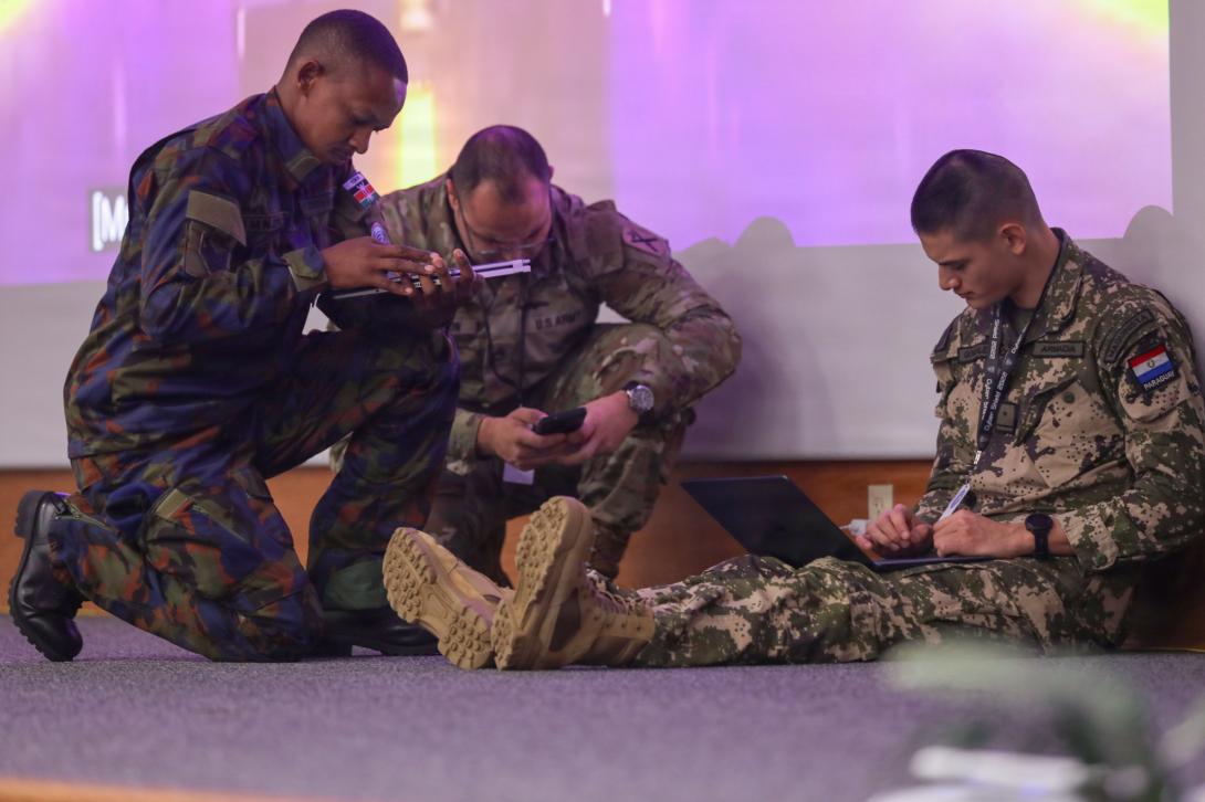 Service members with Kenya (l), U.S. Army (center) and Paraguay (r) collaborate ideas to conduct a cyber challenge at the Professional Education Center in Little Rock, Arkansas on July 17, 2026. Cyber Shield 2026 is the largest annual U.S. Department of Defense cyber training event, consisting of over 1,000 participants from 44 states and territories as well as 23 countries. Credit: U.S. Army National Guard Photo by Sgt. Brittany Burton/382nd Public Affairs Detachment