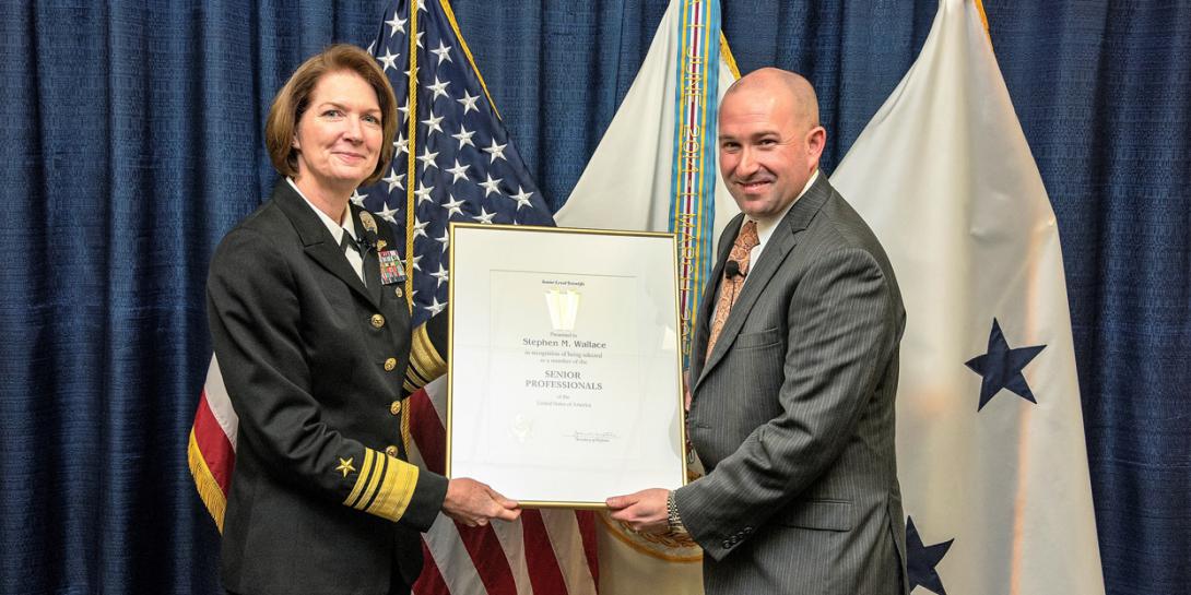 DISA Director Vice Adm. Nancy A. Norton, USN, presents Steve Wallace with his promotion certificate as he takes over the agency’s newly created Emerging Technology (EM) Directorate.