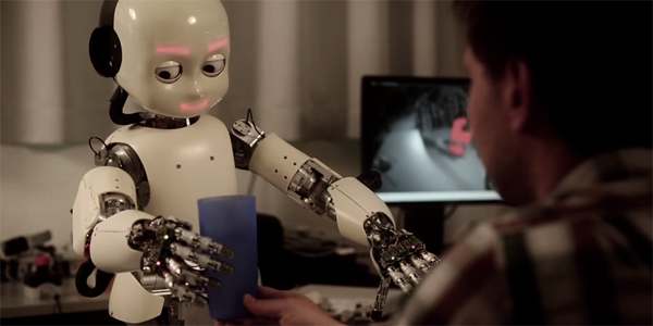 The iCub humanoid robot at IDSIA's robotics lab in Switzerland tries to reach for a blue cup.