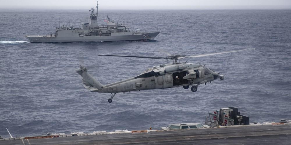 The Royal Australian Navy frigate HMAS Ballarat sails alongside the USS Nimitz as a U.S. Navy helicopter lands on the flight deck. The United States and its Indo-Pacific allies are working to improve their communications interoperability as they face growing challenges in the vast region. Credit: U.S. Navy
