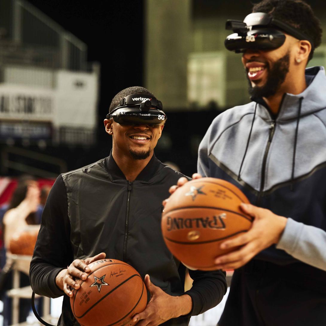 NBA stars Bradley Beal (l) and Anthony Davis use 5G-enabled virtual reality goggles to shoot baskets prior to an NBA All-Star game. Video with extremely low latency will enable 5G users to operate complex machinery from great distances, opening up new work-at-home tasks that previously required on-site presence.  Verizon