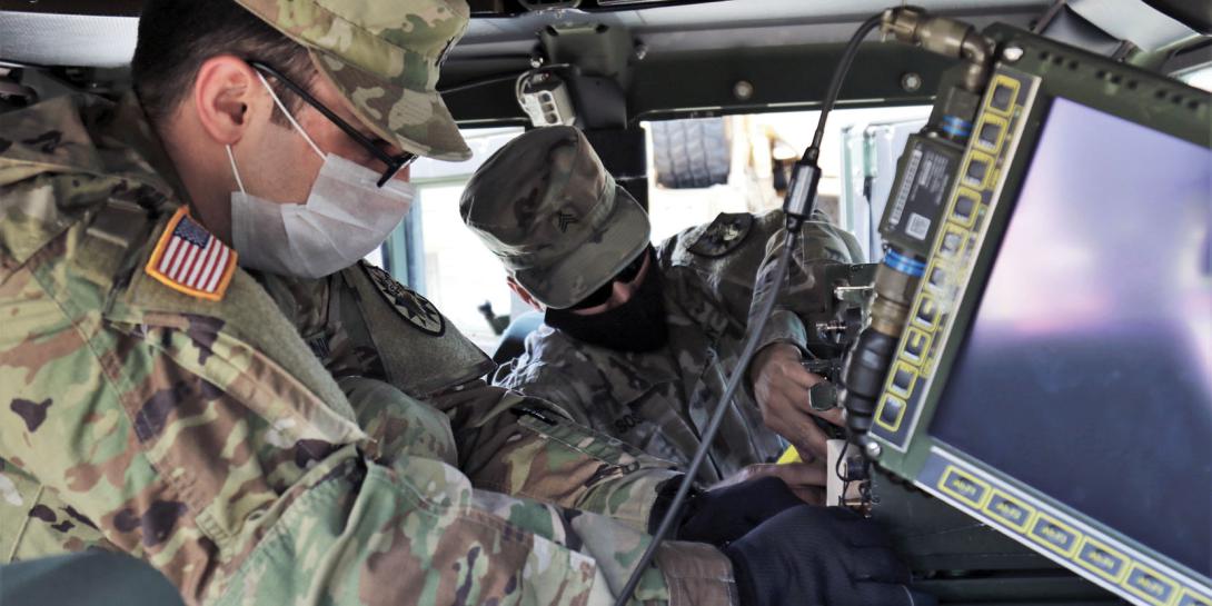 Army Sgt. Evan Tosunian (l) and Sgt. Allan Sosa, both assigned to the California Army National Guard’s 224th Sustainment Brigade, install single-channel ground and airborne radio systems in a Humvee at the National Guard armory in Long Beach, California, in May. The Army’s standardized, reprogrammable encryption chip known as RESCUE will help secure communications for radios, computers, unmanned vehicles and other systems. Credit: Army Staff Sgt. Matthew Ramelb, California Army National Guard