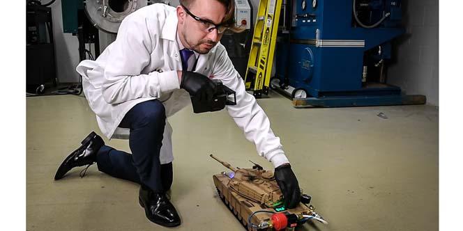 Army researcher Anthony J. Roberts powers a radio-controlled toy tank with hydrogen harvested from a unique chemical reaction. U.S. Army photo by David McNally 