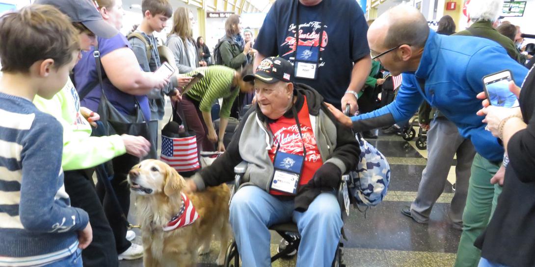 People young and old—and even golden retriever Biscuit—reached out to welcome World War II and Korean War veterans arriving at Reagan National Airport as part of the Honor Flight program.