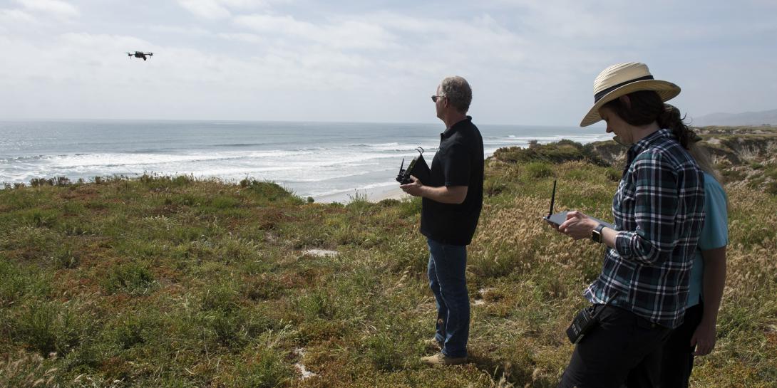 On the beaches at Camp Pendleton, Cory Stephanson, president and CEO, Broadband Discovery Systems Inc., launches a sensor-laden drone that collects data about buried mine materials while Dr. Rosemarie Oelrich, scientist, Naval Surface Warfare Center Carderock, monitors the information on a handheld Android device.