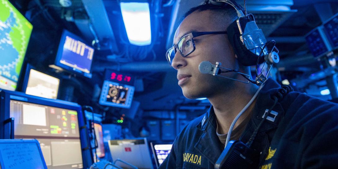 A U.S. Navy lieutenant stands watch in the command control center aboard an amphibious transport dock ship as part of the Boxer Amphibious Ready Group and 11th Marine Expeditionary Unit team. The Navy and the Marine Corps are undertaking a rebuild of their information technology capabilities in the face of increased global threats.