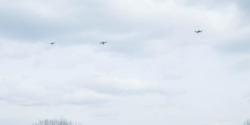 Three drones fly in formation during Marine Corps tests. Logistics-specific platforms would deliver supplies while flying in packs to warfighters in combat.