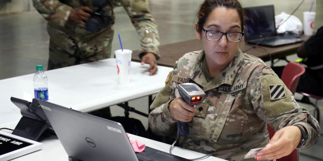 Spc. Damaris Vazquez, USA, an orderly room clerk with 90th Human Resources Company, Special Troops Battalion, 3rd Infantry Division Sustainment Brigade, Fort Stewart, Georgia, scans a common access card at Fort Jackson, South Carolina, to process soldiers in units assisting with Hurricane Florence relief efforts. Credit: Sgt. Elizabeth White, USA/Released