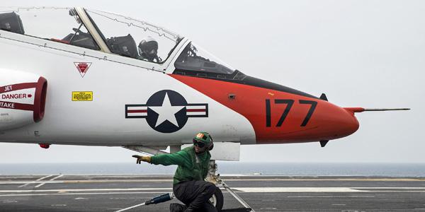 Navy Airman Raheem Malloy clears the catapult to launch a T-45C Goshawk on the flight deck of the aircraft carrier USS George Washington in the Atlantic Ocean in 2016. The Goshawk is assigned to Training Air Wing 1. Navy photo by Petty Officer 3rd Class Bryan Mai. Under its new contract with the Navy, L-3 Communications will support Goshawk aircraft systems.