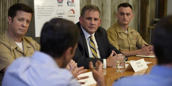 Col. James “Hondo” Geurts (center in necktie), USAF (Ret.), assistant secretary of the Navy for Research, Development and Acquisition, explains the Department of the Navy's creation of so-called NavalX Tech Bridges, designed to bring in more innovation to the Navy and Marine Corps. U.S. Navy photo by Bobby Cummings.