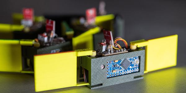 Close-up of a "smarticle"—smart active particle—showing the two 3D-printed arms, light sensor and motor. Credit: Rob Felt, Georgia Tech