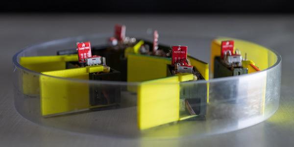 Five identical "smarticles” interact with one another in an enclosure. By nudging each other, the group—dubbed a "supersmarticle"—can move in random ways. The research could lead to robotic systems capable of changing their shapes, modalities and functions. Credit: Rob Felt, Georgia Tech
