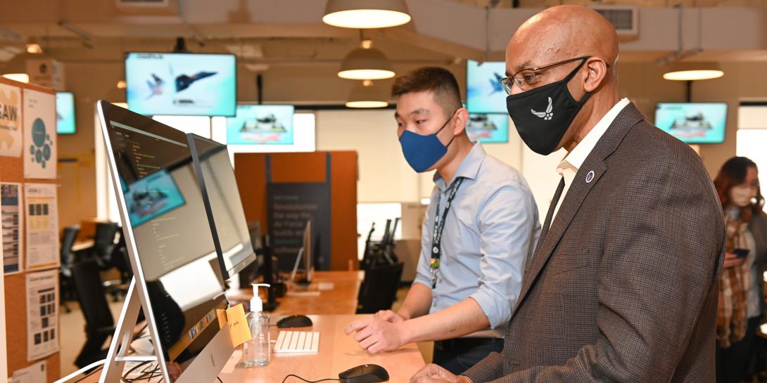 U.S. Air Force Chief of Staff Gen. Charles Q. Brown, USAF, looks on in a demonstration of how to fix code in minutes as part of the Air Force's Kessel Run. The Air Force is building an information enterprise that will enable both users and shapers of data systems to access needed information from a single source. Credit: U.S Air Force